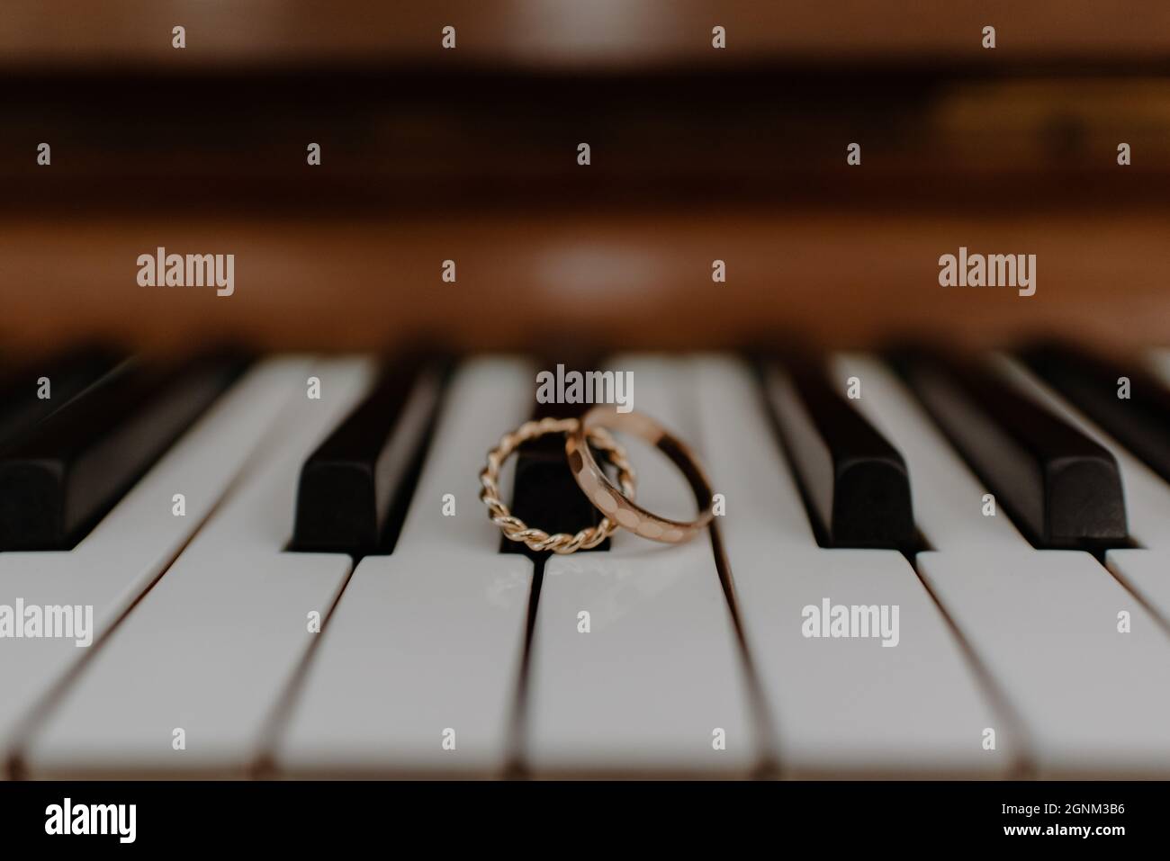 Nahaufnahme eines Paares Eheringe auf einem Klavier Stockfoto