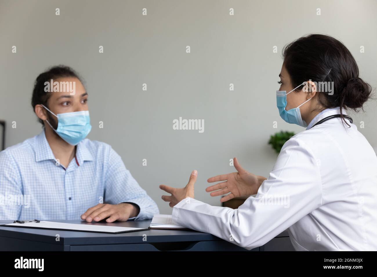 Indischer Arzt und covid Patient trägt Gesichtsmasken Stockfoto