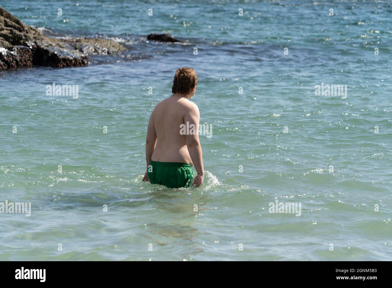 Ingwer-Mann wagt in Kynance Cove in Cornwall, Großbritannien, ins Wasser. 08.09.21 Stockfoto