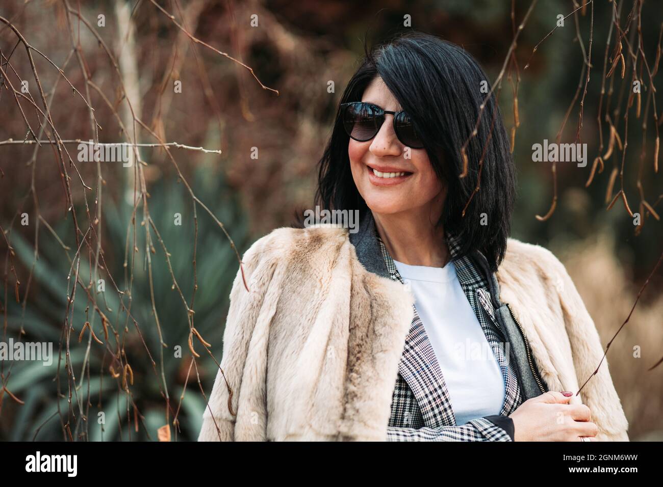 Moderne Frau mittleren Alters in Pelzmantel, lächelnd Stockfoto