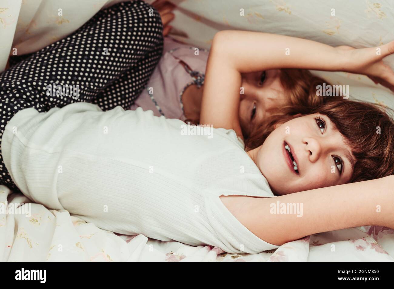 Nette kleine Mädchen, Schwestern, die morgens aufwachen. Kinder im Schlafanzug, schlafen, Mädchenzimmer Stockfoto