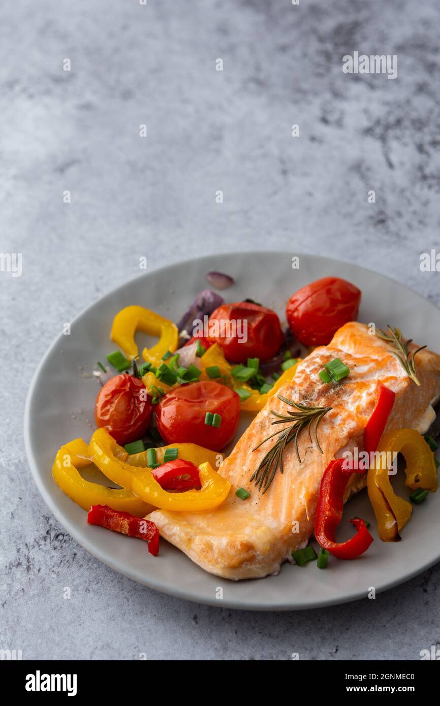 Gebackenes rotes Fischfilet Arktischer Saibling auf einem Teller mit Gemüse aus nächster Nähe, leckeres herzhaftes, gesundes Abendessen Stockfoto