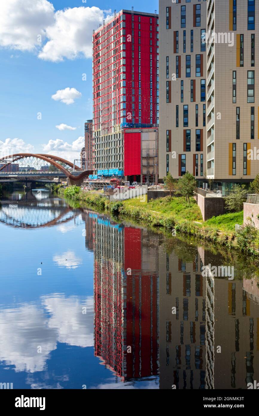 Der Apartmentblock Novella (im Bau) neben den Slate Yard Apartments, der sich im Fluss Irwell widerspiegelt. Salford, Manchester, England, Großbritannien Stockfoto