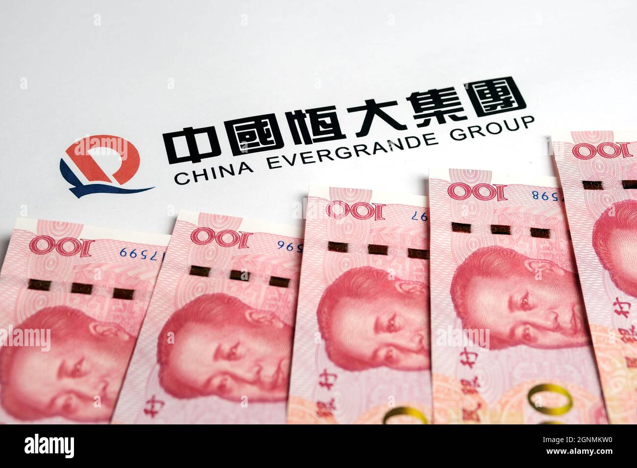 Yuan-Banknoten und das Logo der China Evergrande Group. Konzept. Stafford, Großbritannien, 26. September 2021. Stockfoto