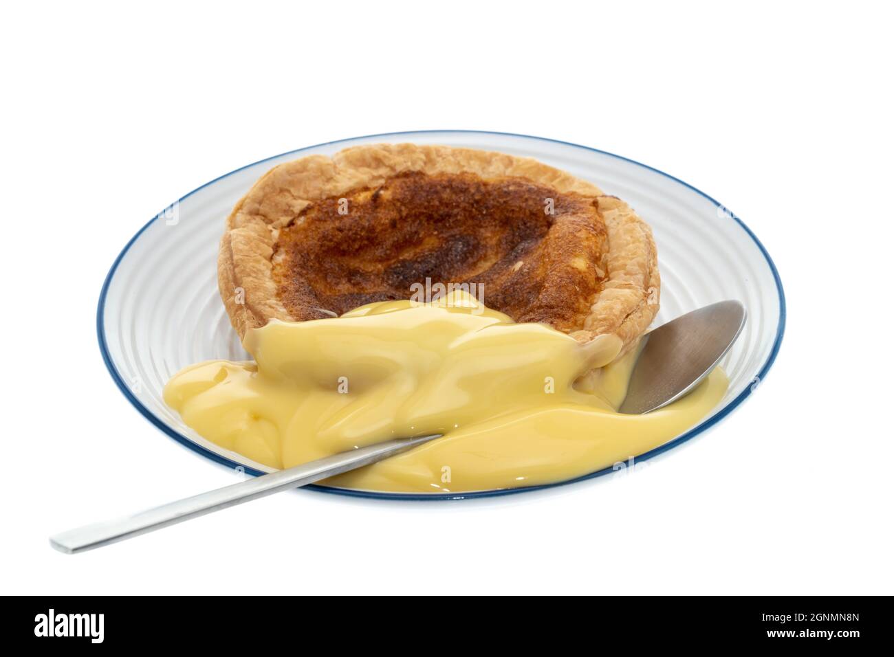 Ein ganzer Bakewell Pudding auf einem Teller - weißer Hintergrund Stockfoto