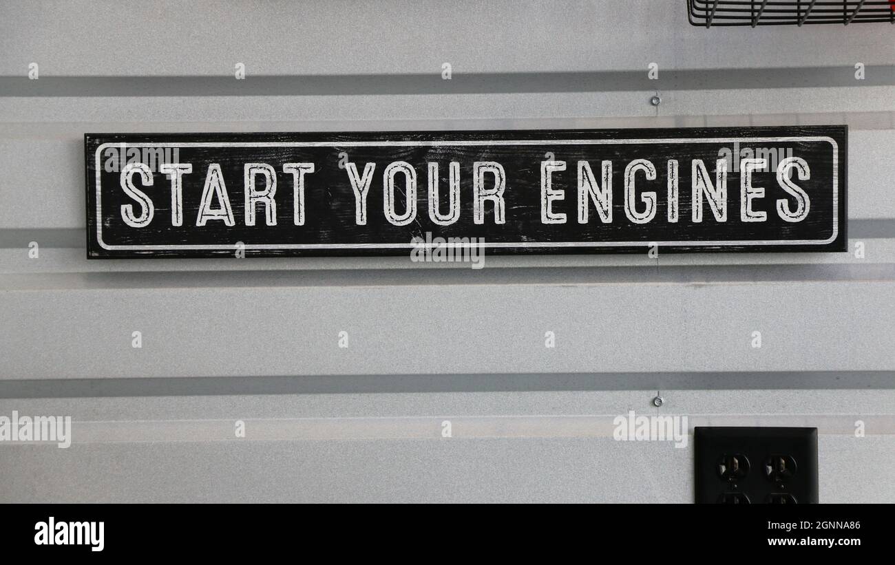 Schwarz-weißes Schild mit der klassischen Anleitung zum Start eines Autorennens - Starten Sie Ihre Motoren. Stockfoto
