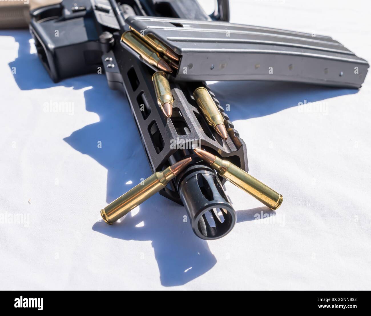 Ein Gewehrmagazin mit 223 Kalibern auf einem kurzen AR15-Gewehr mit Barreled und zusätzlichen Kugeln daneben auf weißem Hintergrund Stockfoto