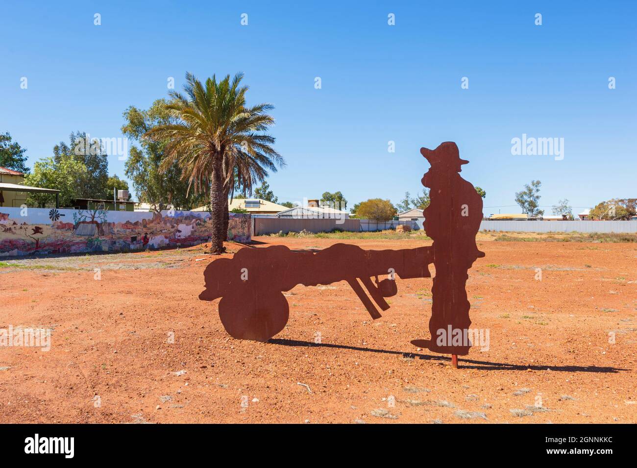Metallkunstwerk eines alten goldminers, der in der kleinen ländlichen Stadt Cue, Region Murchison, Westaustralien, eine Schubkarre schiebt Stockfoto