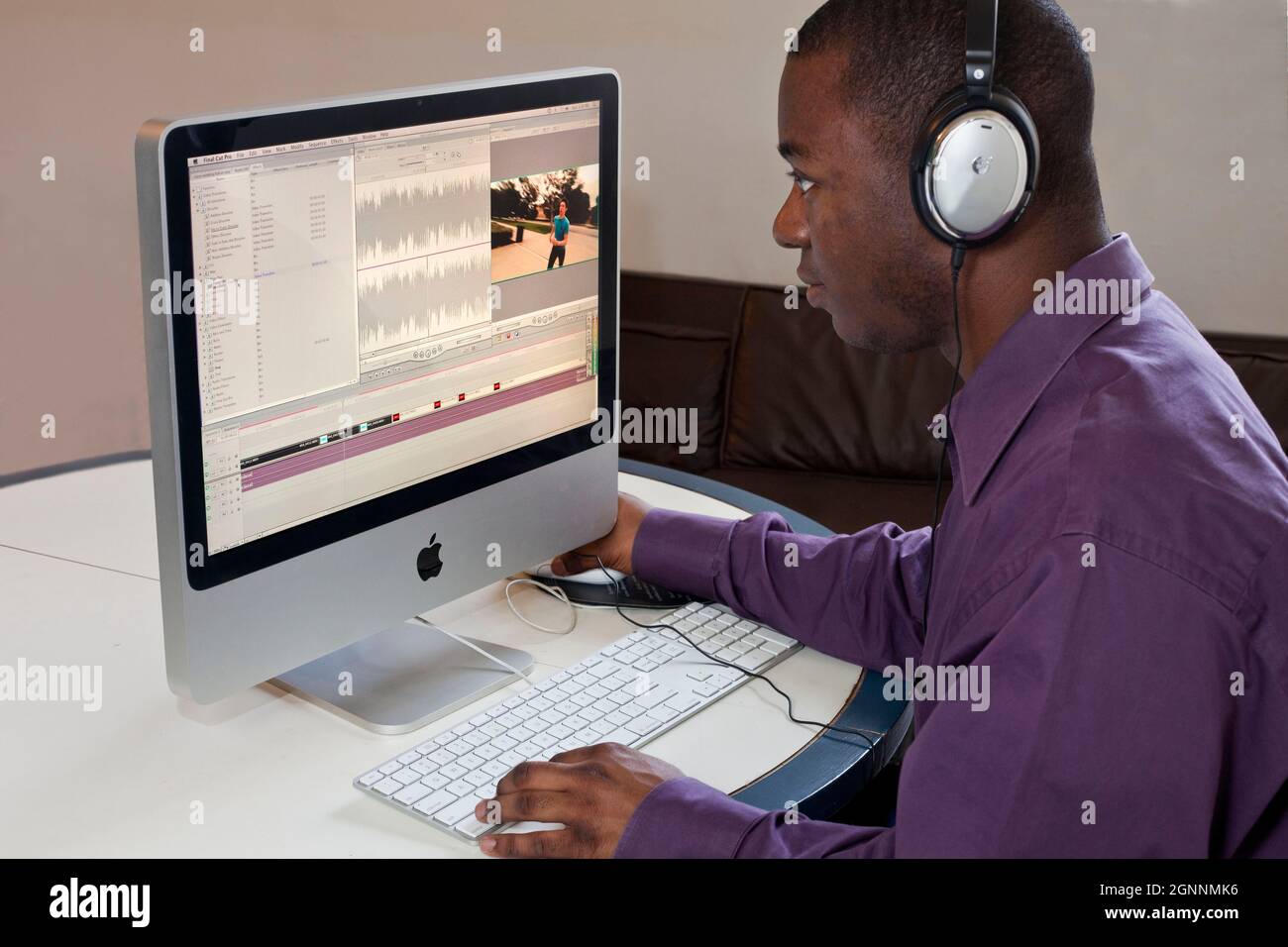 Video Editor verwendet Final Cut Pro bei Computer Home Office 1 MR - Model veröffentlicht Stockfoto