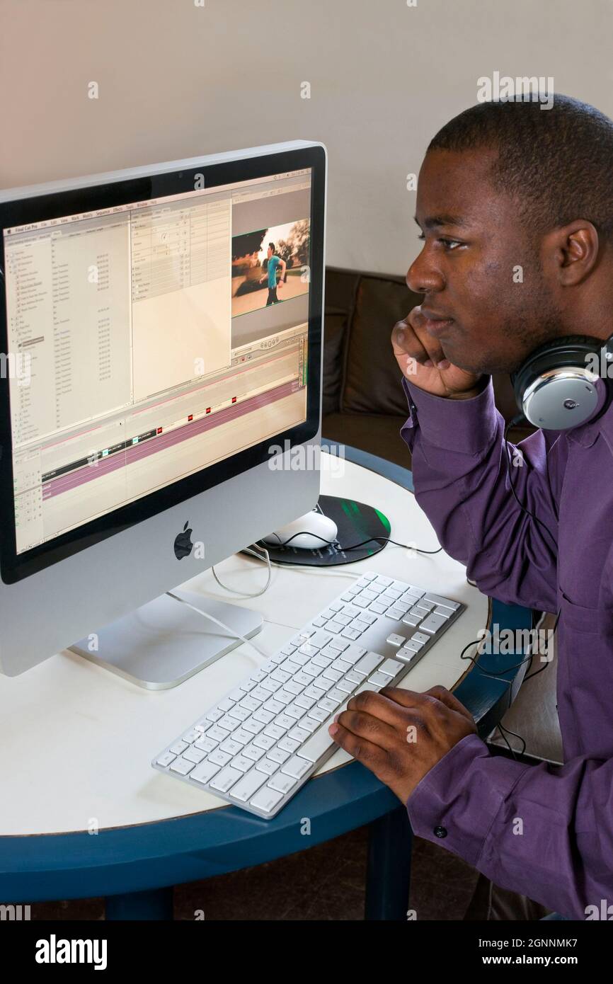 Video-Editor verwendet Final Cut Pro bei Computer Home Office 2 MR - Model veröffentlicht Stockfoto