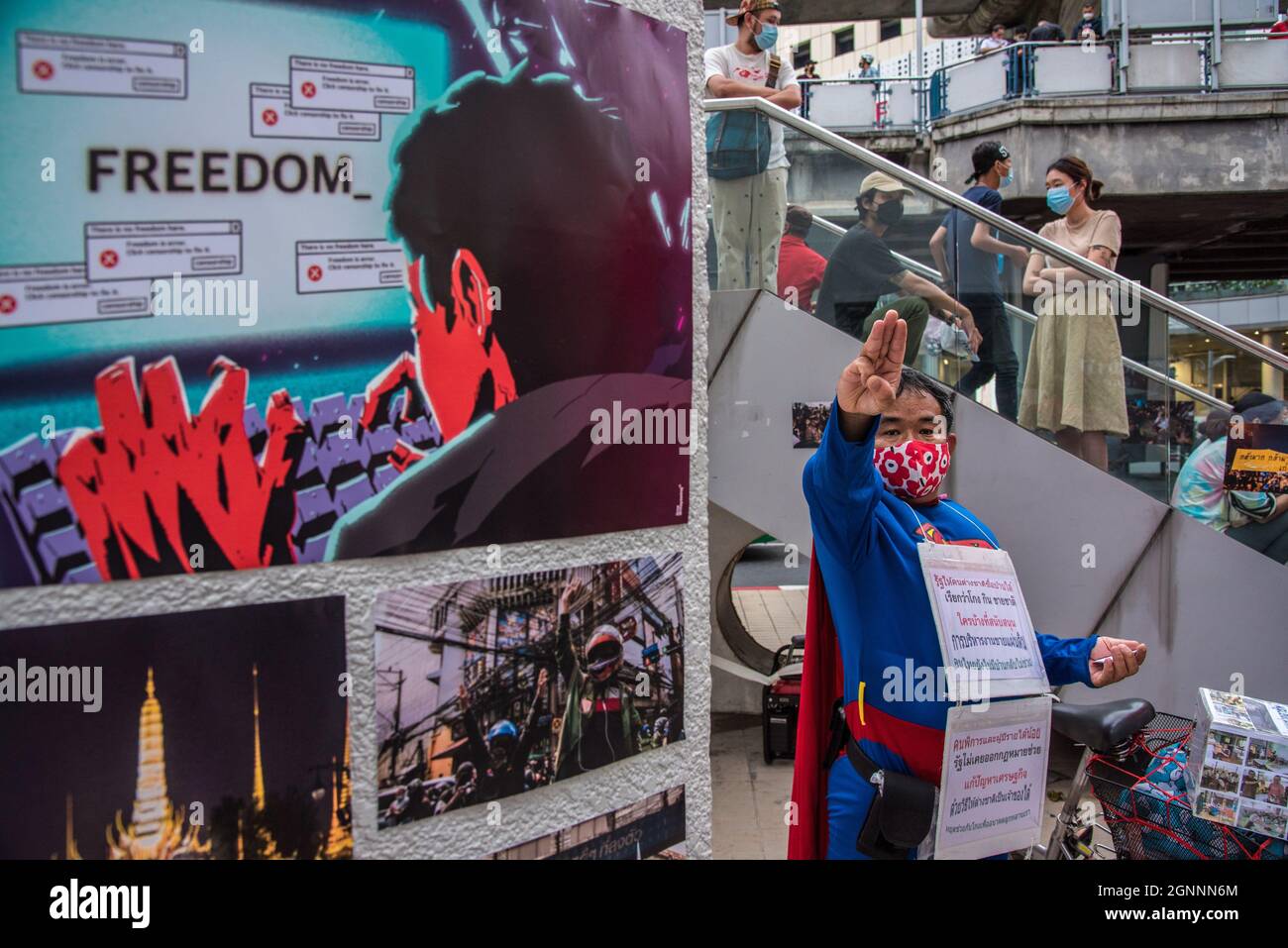 Bangkok, Thailand. September 2021. Ein als Superman gekleideter Protestler grüßt mit drei Fingern neben den Kunstwerken, die während der Demonstration ausgestellt werden.Pro-Demokratie-Demonstranten versammelten sich am 26. September im Bangkok Art and Culture Center (BACC). 2021 zum 1. Jahrestag der politischen Bewegung in Thailand, die von der United Front of Thammasat and Demonstration (UFTD) angeführt wurde und den Rücktritt von Prayut Chan-O-Cha und die Monarchie-Reform forderte. Kredit: SOPA Images Limited/Alamy Live Nachrichten Stockfoto
