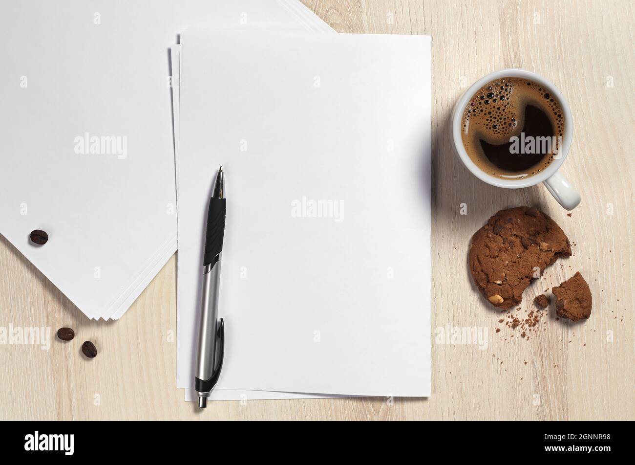 Tasse Kaffee mit Keksen, saubere Blätter Papier und Stift auf Holzschreibtisch, Draufsicht. Platz für Ihren Text Stockfoto