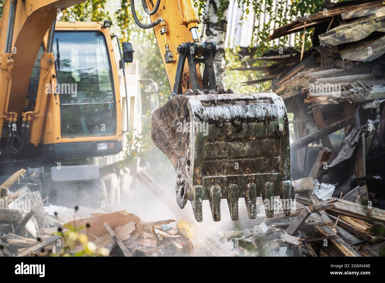 Baggereimer bricht altes Haus. Abriss des Gebäudes. Ausbau der Struktur. Stockfoto