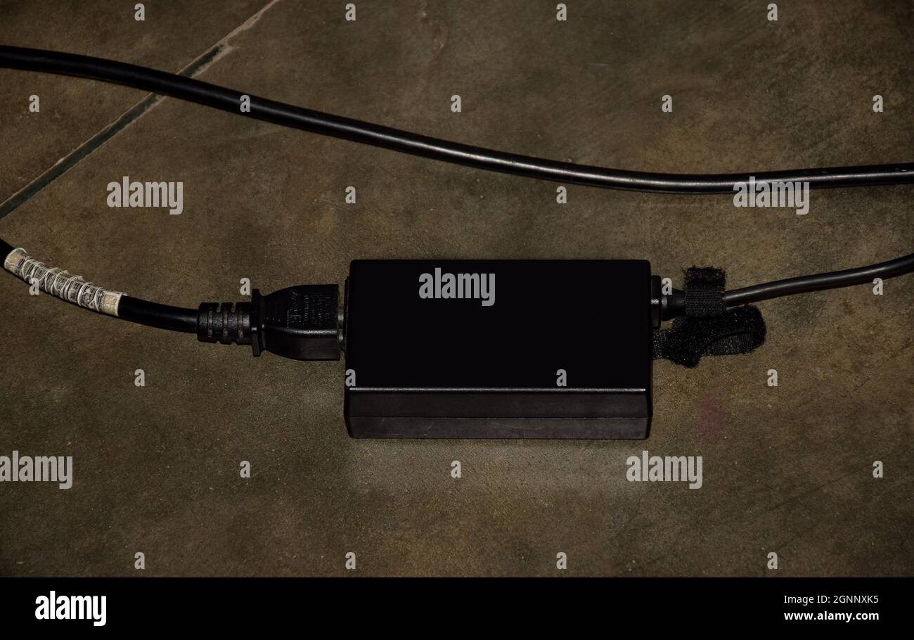 Laptop-Adapter oder -Ladegerät liegen auf dem Boden Stockfoto