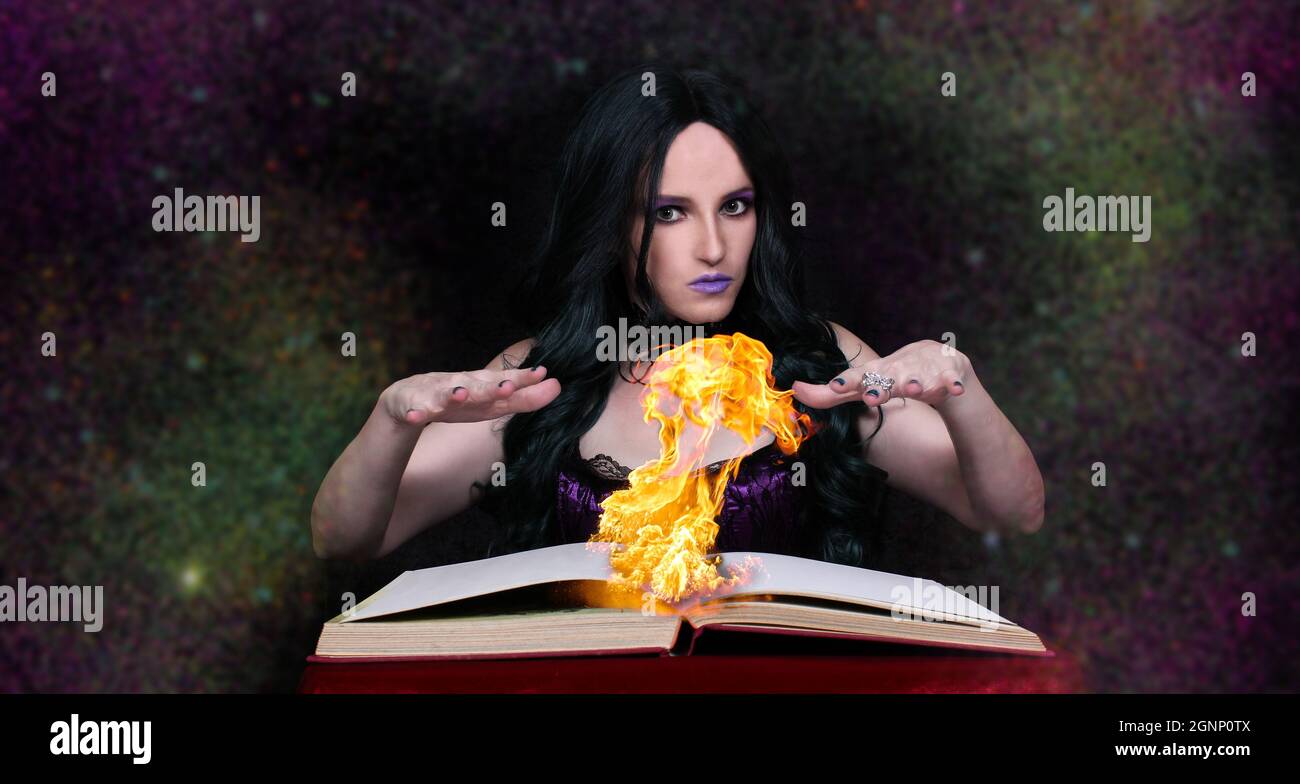 Hexe mit flammenden Zauberbuch und Galaxy Hintergrund Stockfoto