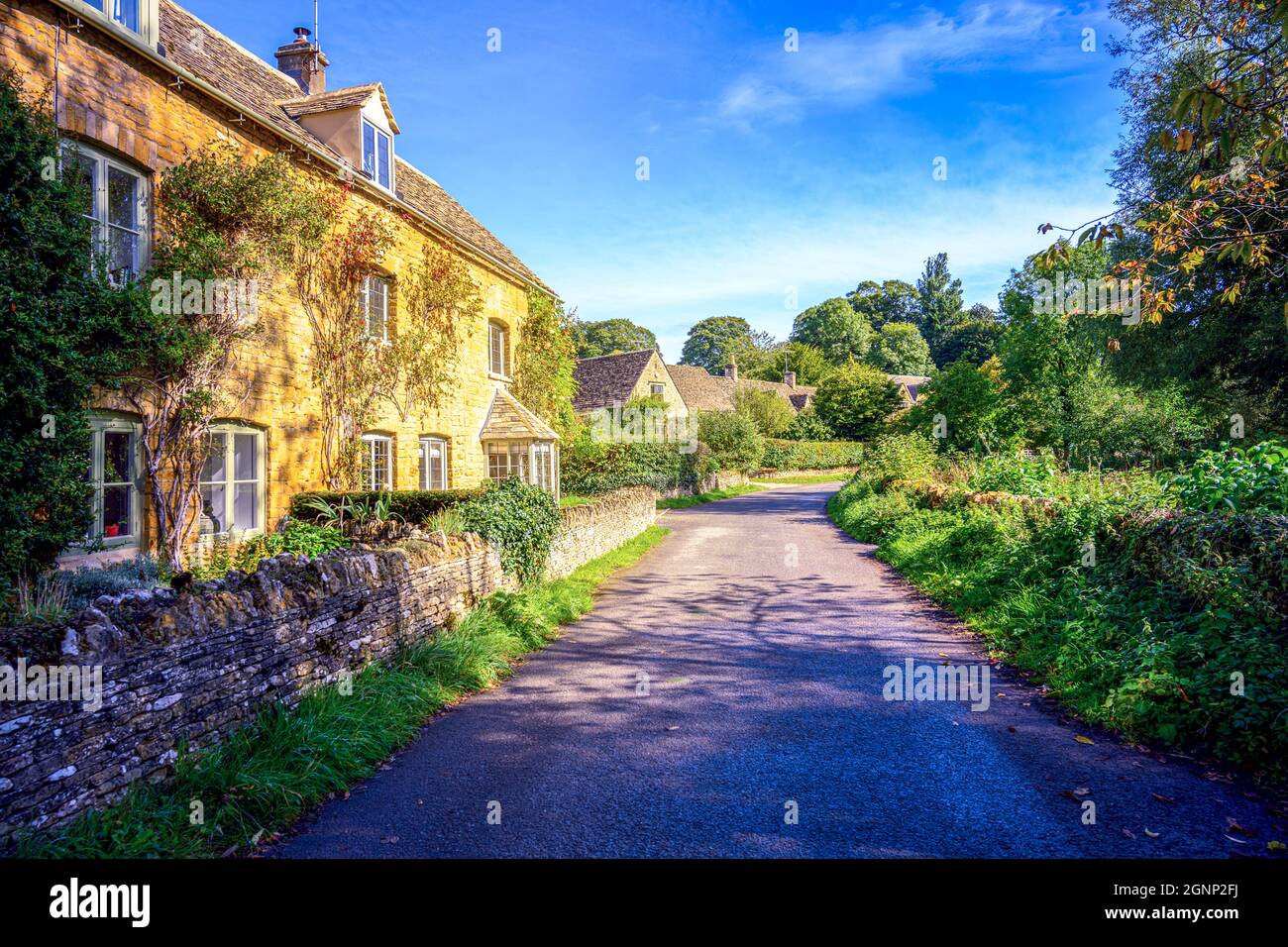 Traditionelle Steinhütten entlang einer Landstraße im hübschen Cotswold Cotswolds-Dorf Upper Slaughter Gloucestershire England, Großbritannien Stockfoto