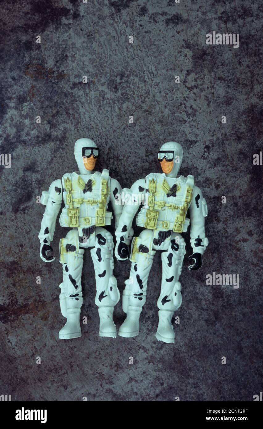 Plastikmodelle von zwei Männern in Brille und Action-Ausrüstung stehen, als ob sie Pläne oder Witze teilen Stockfoto