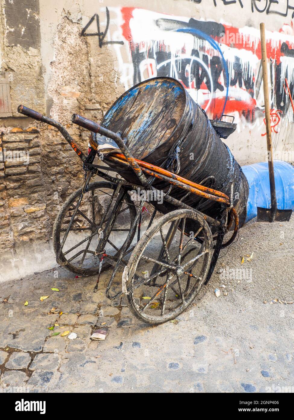 Ein Behälter voller Teer auf einem Handwagen - Rom, Italien Stockfoto