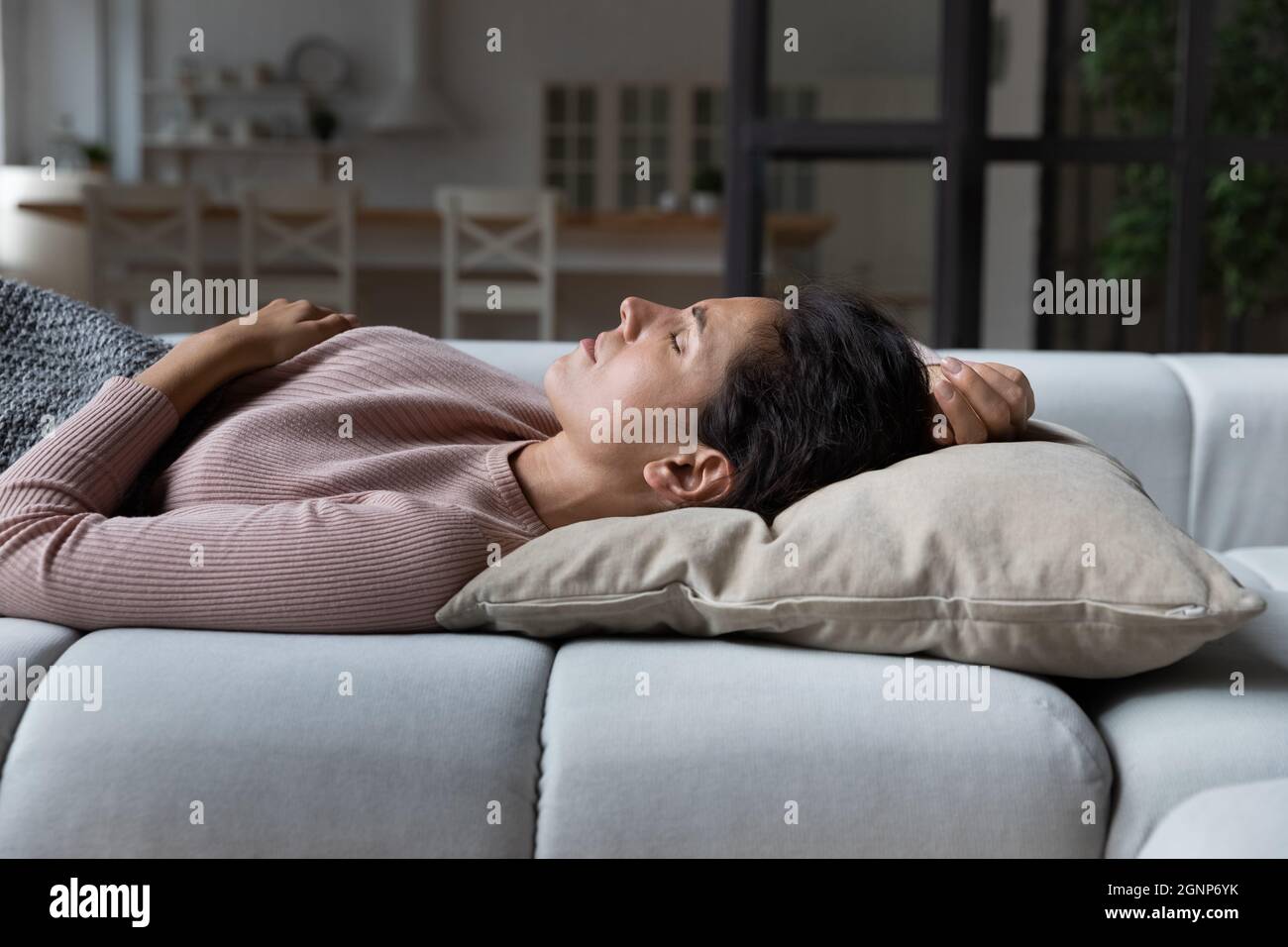 Ruhige Frau schlafen friedlich auf der Couch zu Hause Stockfoto