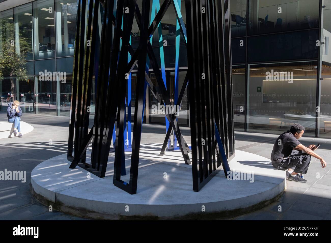 Ein Stadtarbeiter kommt am 24. September 2021 in London, England, an der Skulptur „Kosmos“ vorbei, einem Kunstwerk von Eva Rothschild in der City of London, dem Finanzviertel der Hauptstadt. Cosmos (2019) besteht aus drei 3,5m hohen Lattenrost-Strukturen, die sich schlank und stützen und ist Teil des Sommerprojekts Art in the City. Stockfoto