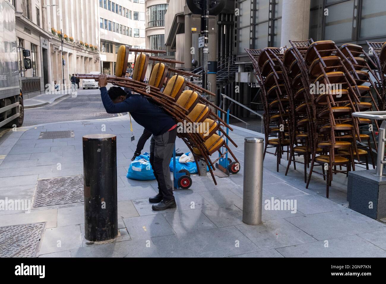 Nach einer Veranstaltung in Lloyds of London in der City of London, dem Finanzdistrikt der Hauptstadt, am 24. September 2021 in London, England, beladen Auftragnehmer des Möbelherstellers „Well dressed Tables“ hohe Stapel von Veranstaltungsstühlen in den Lastwagen des Unternehmens. Stockfoto