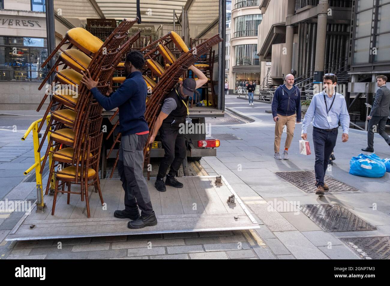 Nach einer Veranstaltung in Lloyds of London in der City of London, dem Finanzdistrikt der Hauptstadt, am 24. September 2021 in London, England, beladen Auftragnehmer des Möbelherstellers „Well dressed Tables“ hohe Stapel von Veranstaltungsstühlen in den Lastwagen des Unternehmens. Stockfoto