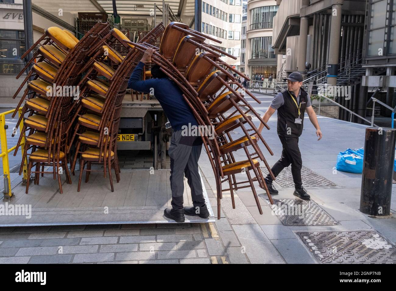 Nach einer Veranstaltung in Lloyds of London in der City of London, dem Finanzdistrikt der Hauptstadt, am 24. September 2021 in London, England, beladen Auftragnehmer des Möbelherstellers „Well dressed Tables“ hohe Stapel von Veranstaltungsstühlen in den Lastwagen des Unternehmens. Stockfoto