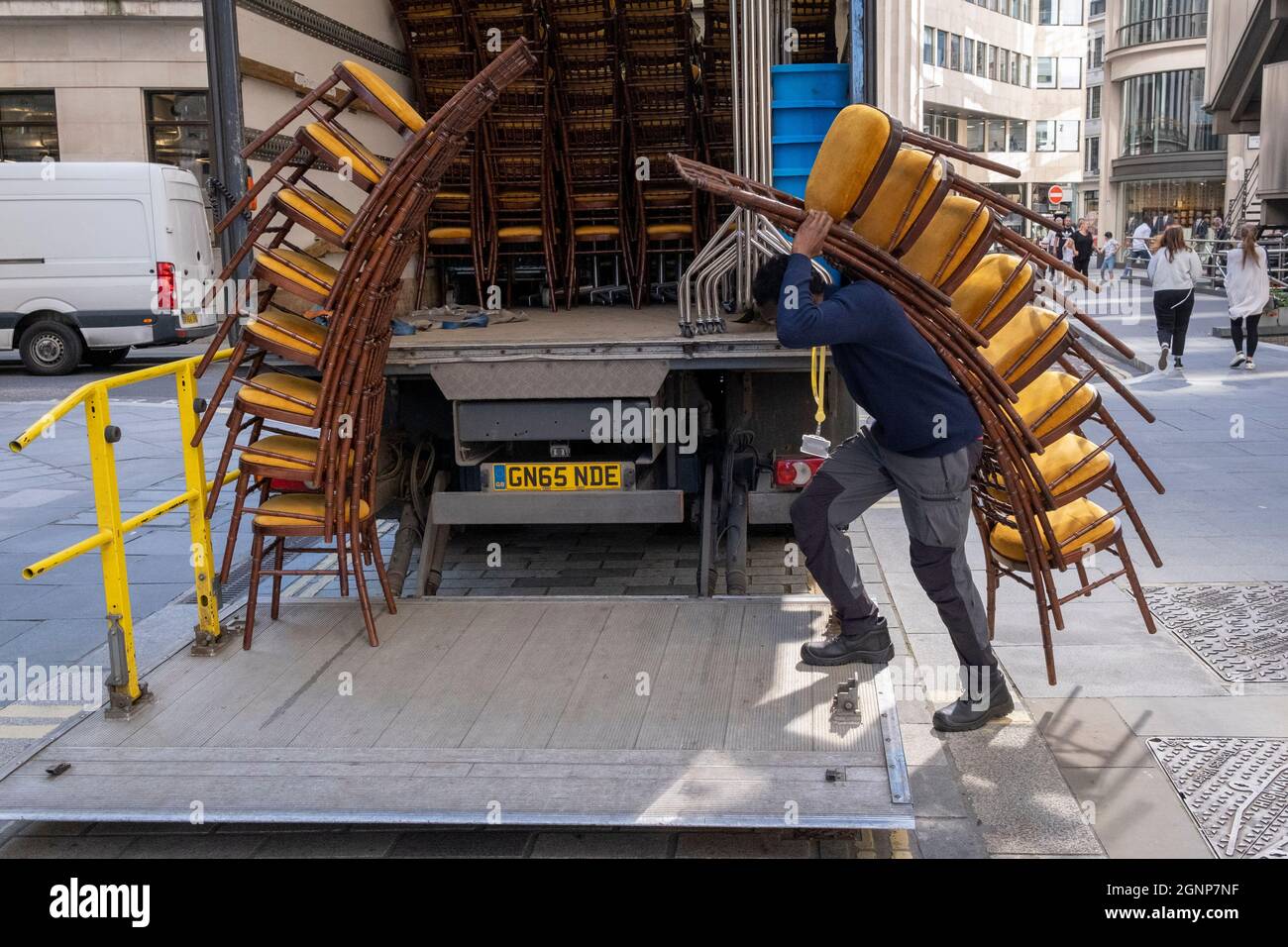 Nach einer Veranstaltung in Lloyds of London in der City of London, dem Finanzdistrikt der Hauptstadt, am 24. September 2021 in London, England, beladen Auftragnehmer des Möbelherstellers „Well dressed Tables“ hohe Stapel von Veranstaltungsstühlen in den Lastwagen des Unternehmens. Stockfoto