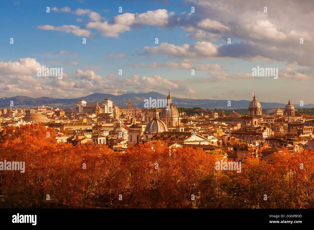 Herbst in Rom. Blick auf die Skyline des historischen Zentrums kurz vor Sonnenuntergang mit alten Denkmälern, barocken Kuppeln und roten Blättern Stockfoto