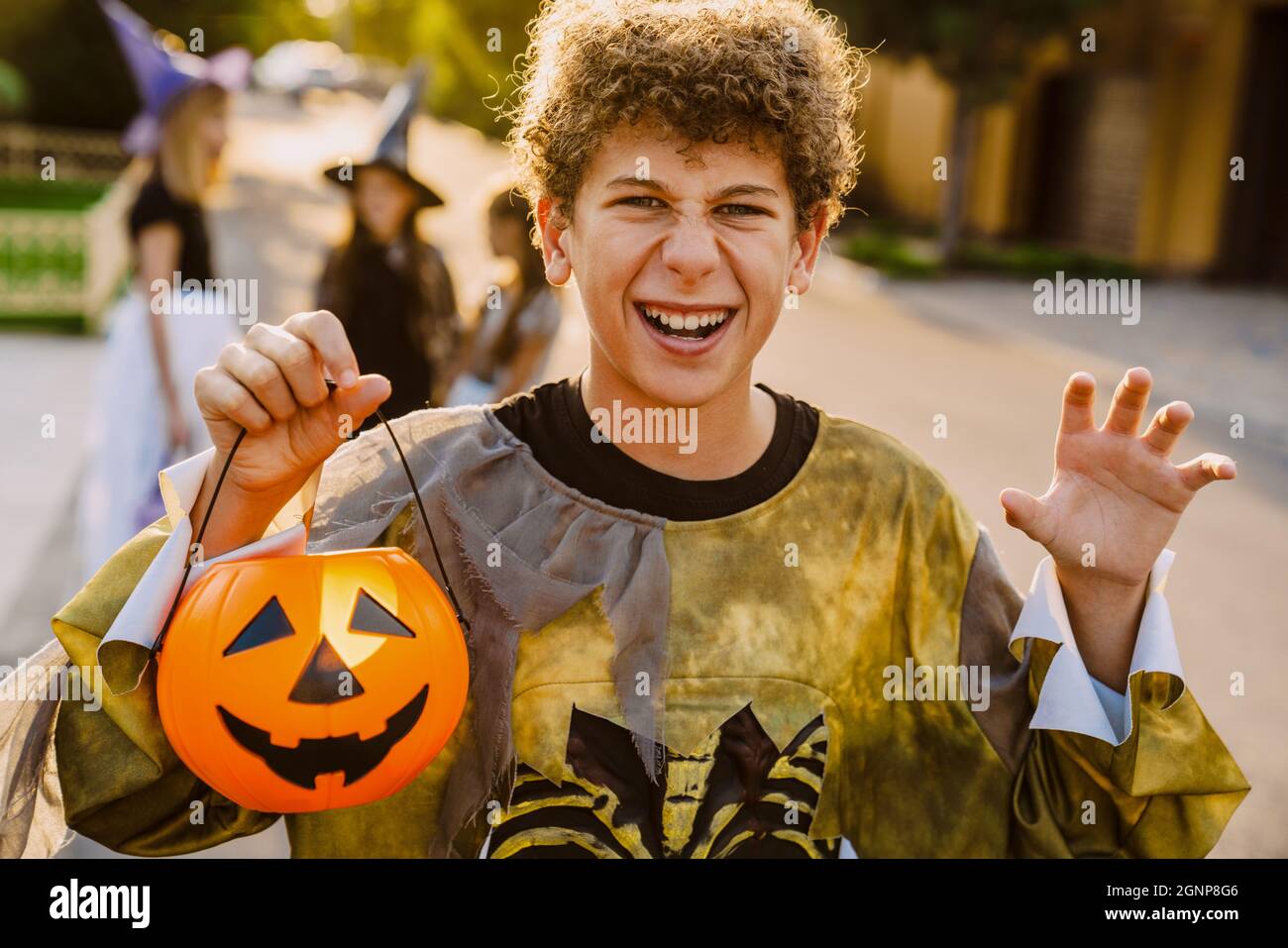 Weißer Junge, der an Halloween im Freien mit ihren Freunden trickst oder behandelt Stockfoto