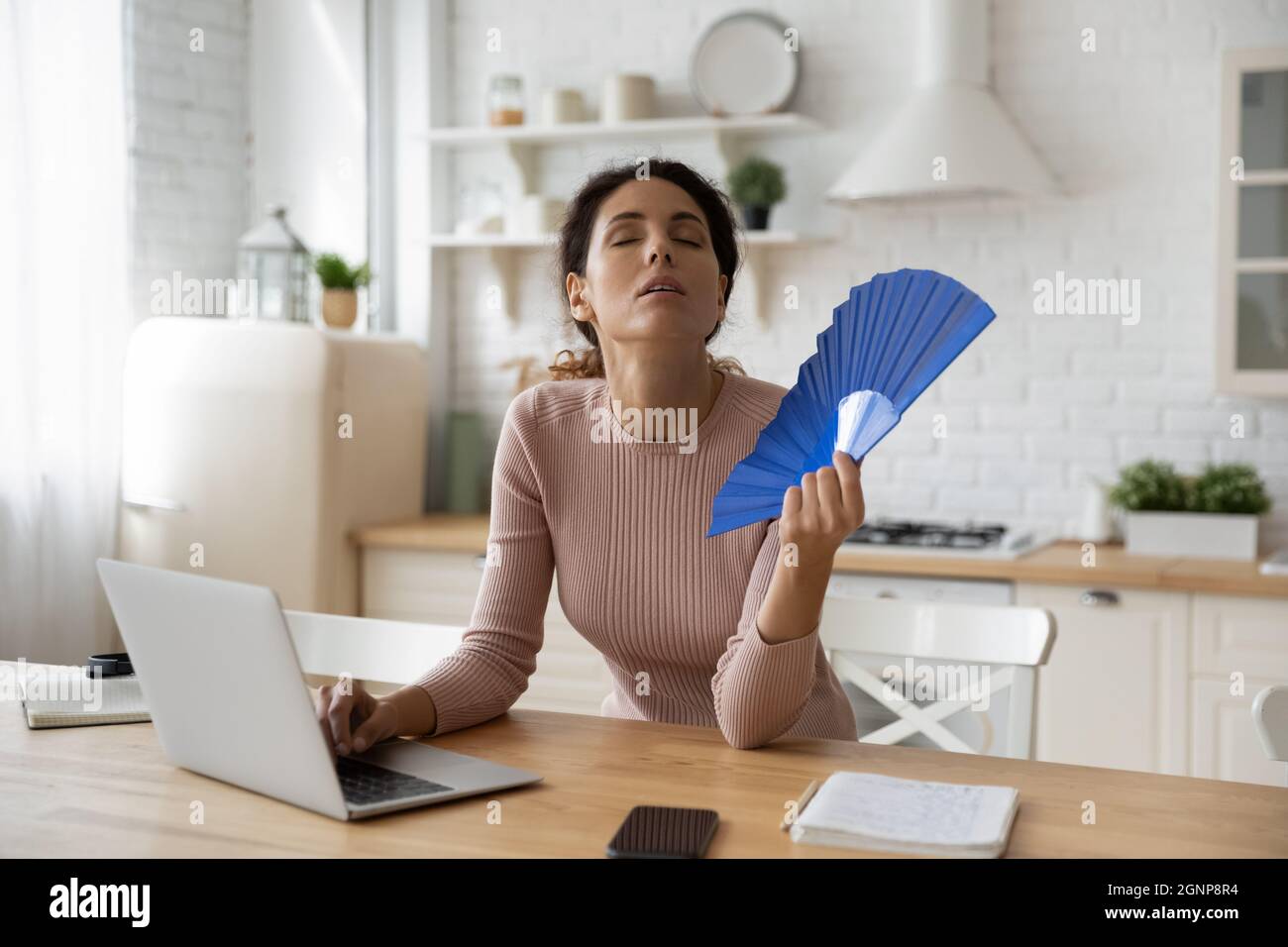 Müde junge Frau arbeiten am Computer mit Waver Stockfoto