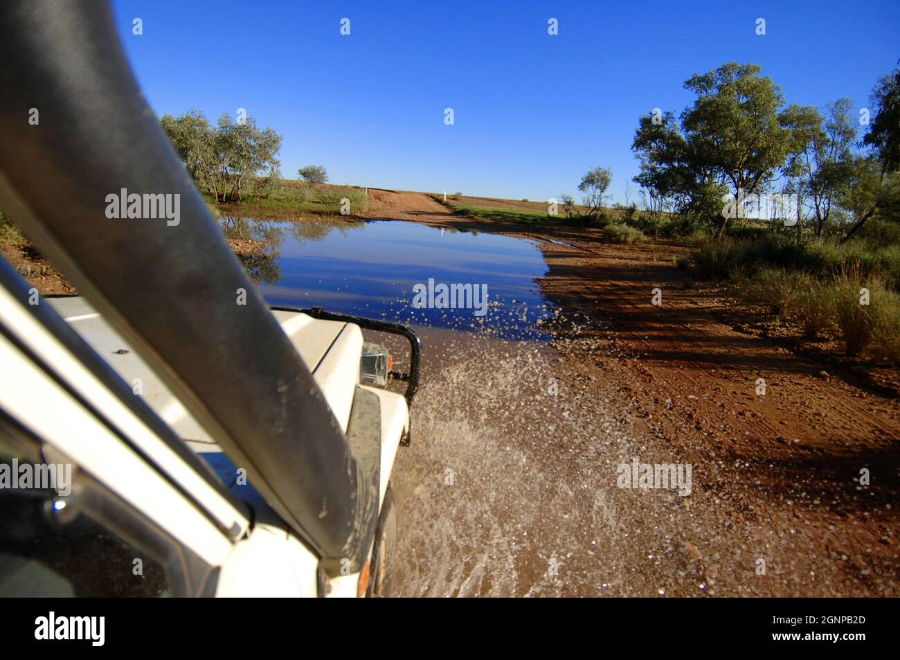 Jeep fährt durch eine Wasserpfütze auf einer unbefestigten Straße, Australien, Oodnadatta Stockfoto