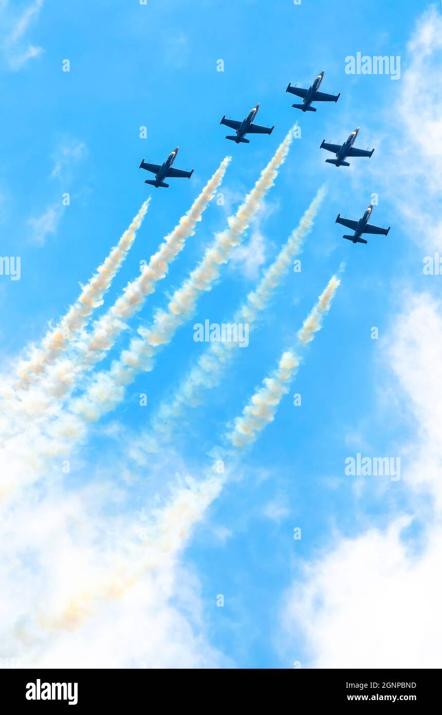 Eine Gruppe von Kampfflugzeugen fliegt mit einer Rauchspur gegen einen blauen Himmel mit Wolken Stockfoto