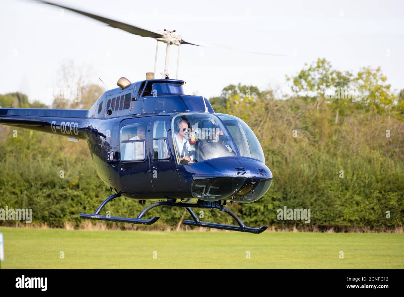 Männliche weibliche Crew Bell Jet Ranger im Schwebeflug mit Beifahrer. G-OCFD. Stockfoto