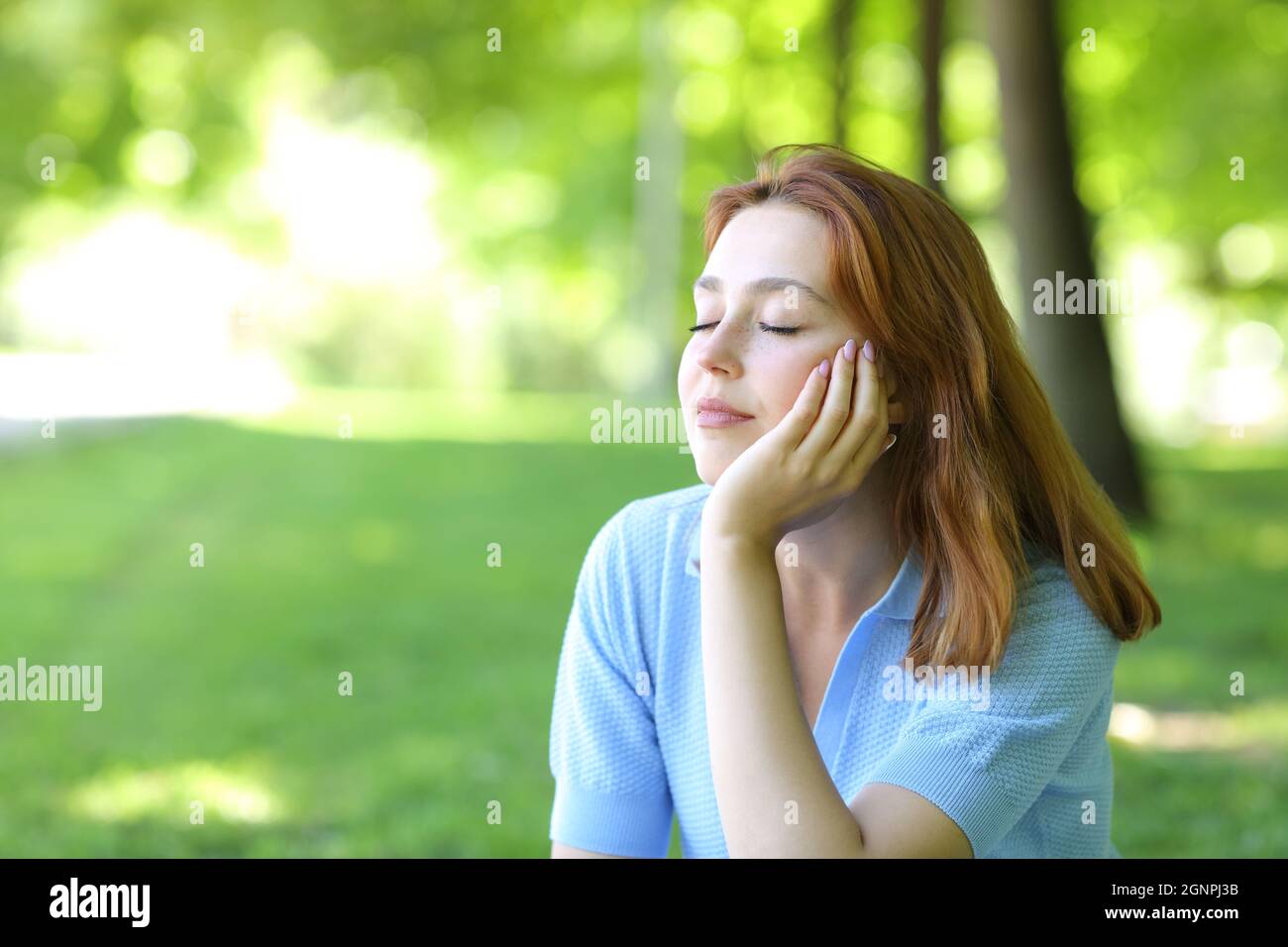 Schöne Frau entspannt sitzen in einem Park Stockfoto