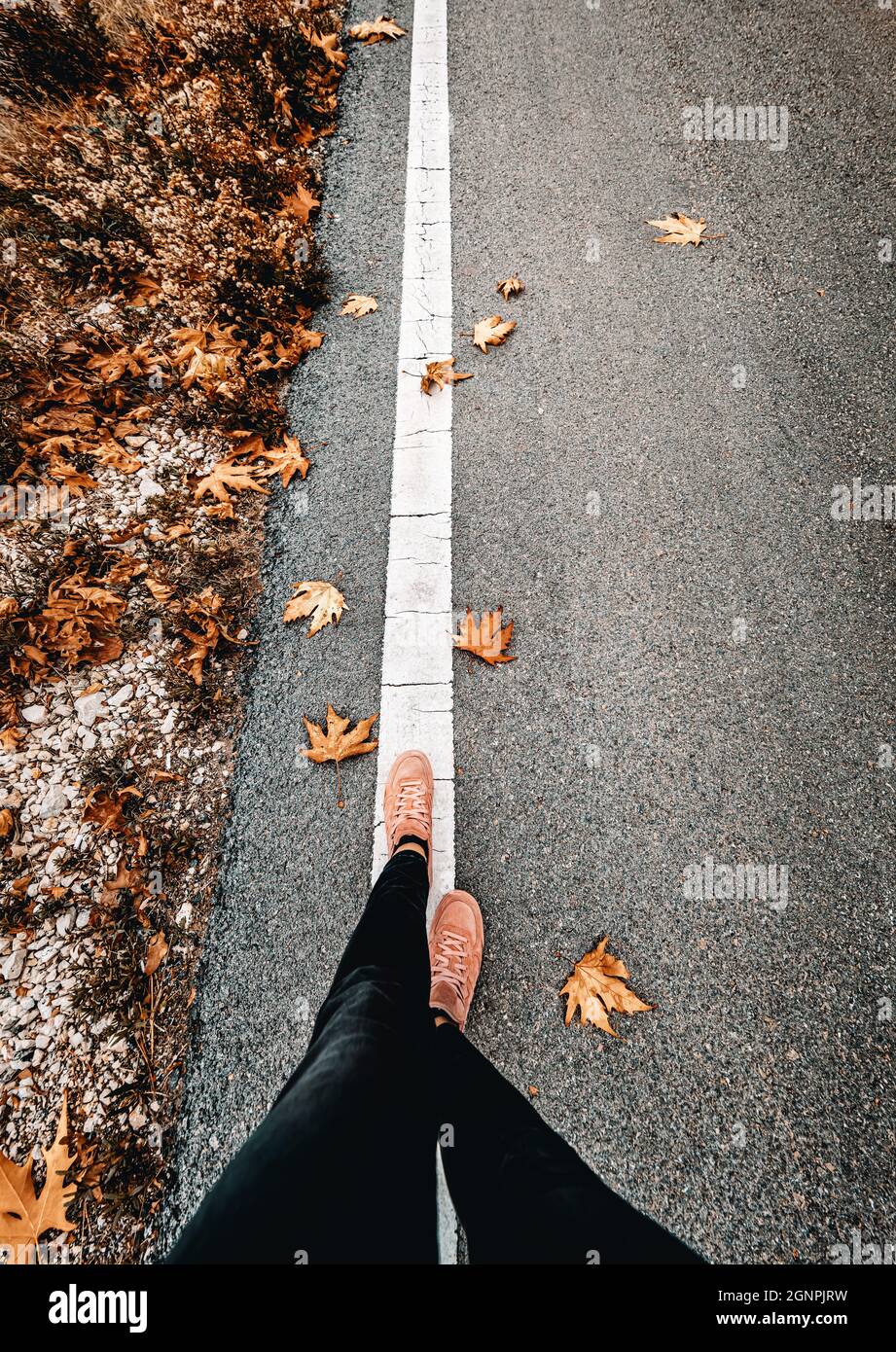 Frau, die im Herbst die Straße entlang läuft. Verbringen Sie Ruhe Herbst Tag allein mit mir. Konzept Für Saisonwechsel. Stockfoto