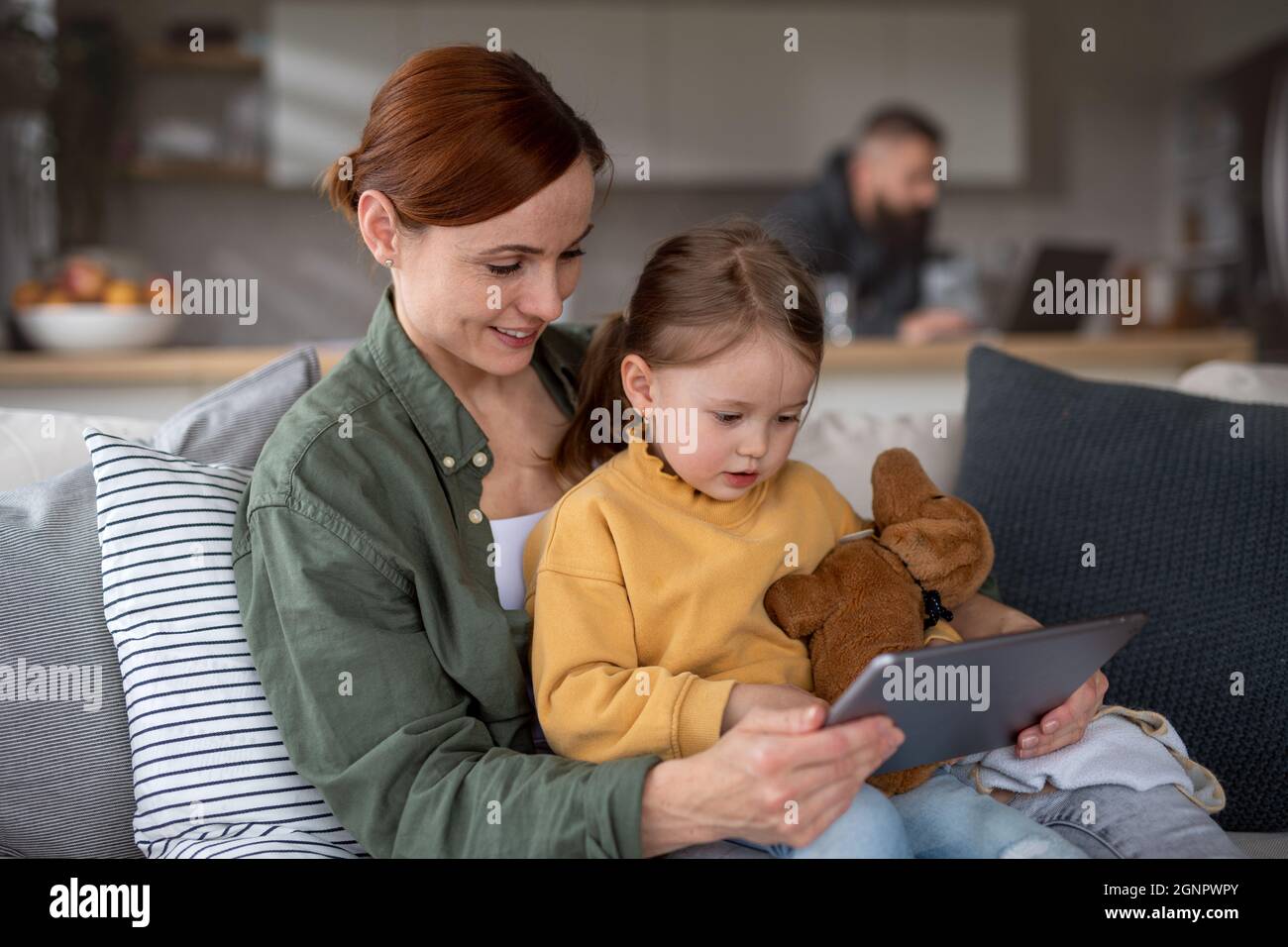 Glückliche Mutter mit kleiner Tochter beobachten Kinder Programm auf Tablet drinnen zu Hause, Single-Parenting-Konzept. Stockfoto