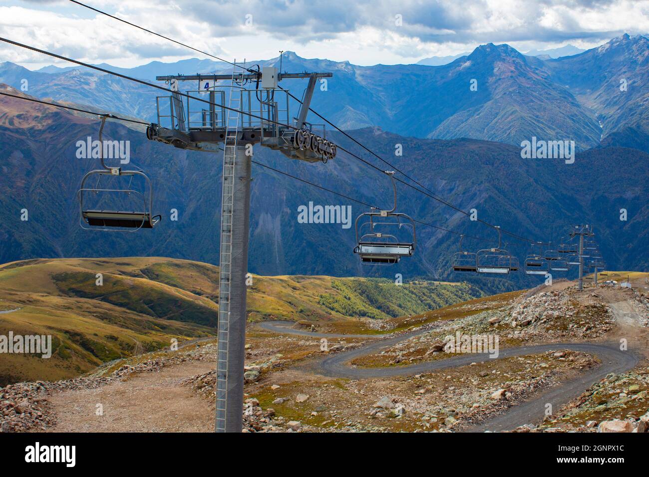 Seilbahn mit offenen Sitzen in den Bergen im Sommer. Skilift im Kaukasus in Georgien. Blick von der Spitze des Berges. Stockfoto