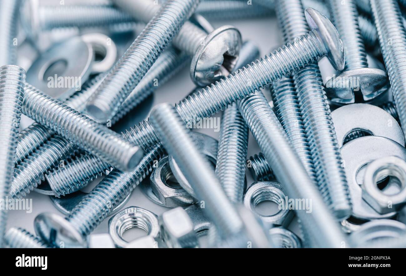 Hintergrund der Nahaufnahme neuer Schrauben und Muttern Stockfoto