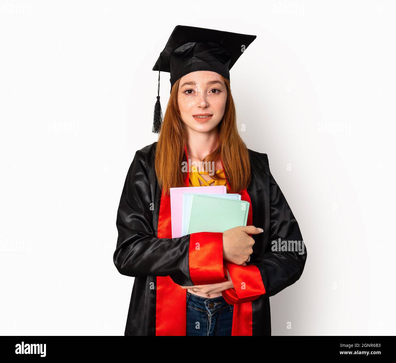 Eine hübsche rothaarige Studentin, die ihre Studienbücher hält und ihren Abschluss mit Erfolg feiert. Hochwertige Fotos Stockfoto