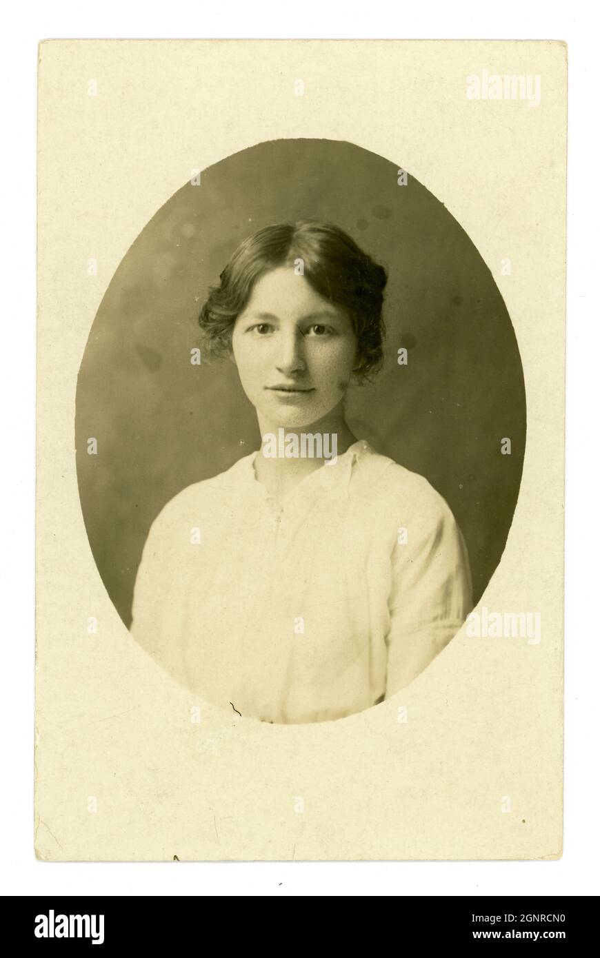 Originalpostkarte aus dem frühen 20. Jahrhundert mit ovalem Porträt einer schönen, ruhigen jungen Dame von E.A. Osborne, Falmouth, Cornwall, England, Großbritannien um 1913. Stockfoto