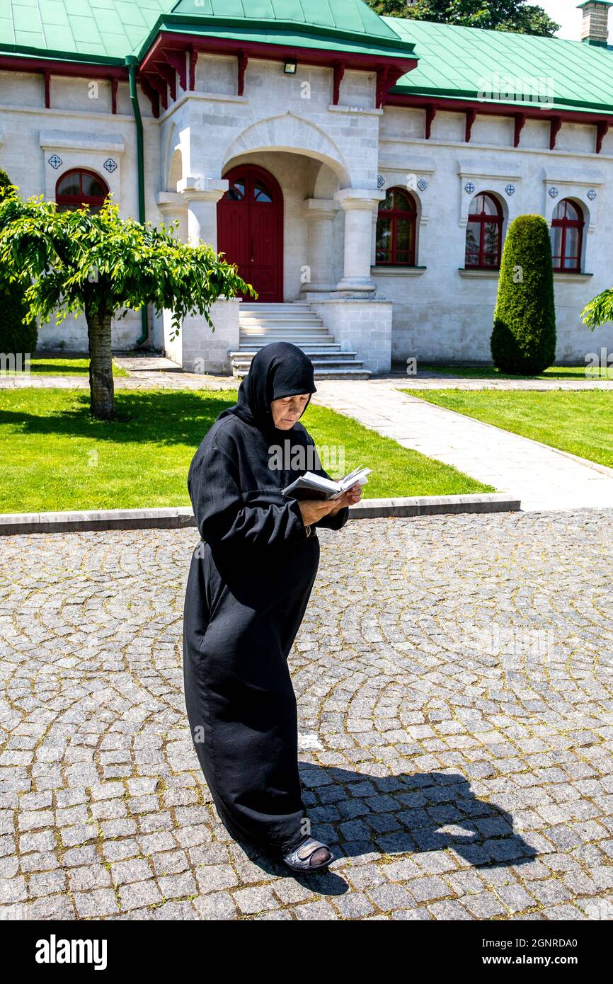 Nonne beim Wandern und Lesen im Kloster Curchi, Moldawien. Stockfoto