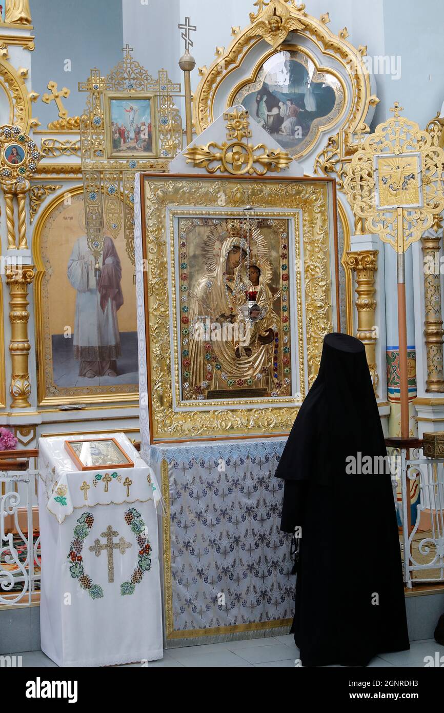Nonne mit Blick auf eine Ikone in der orthodoxen Klosterkirche von Japca, Moldawien Stockfoto