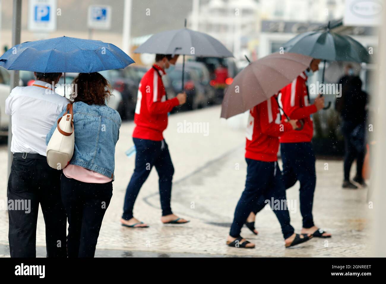 Menschen, die mit Regenschirm in regnerischen Tag Szene zu Fuß. Nazare. Portugal. Stockfoto