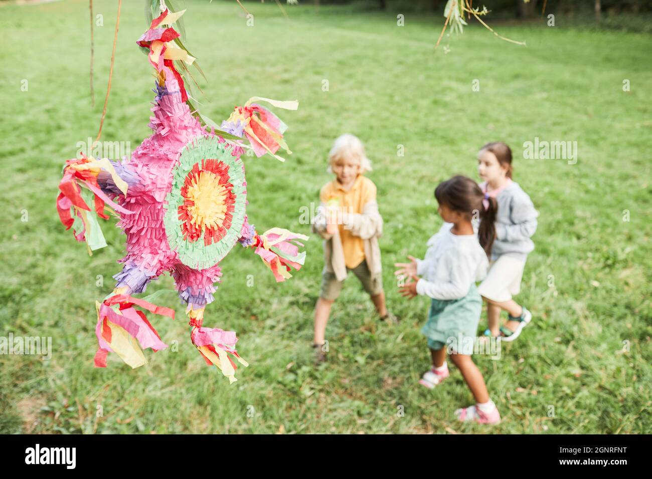 Hintergrundbild von rosa Pinata auf Geburtstagsparty mit verschiedenen Gruppe von Kindern spielen im Freien, kopieren Raum Stockfoto