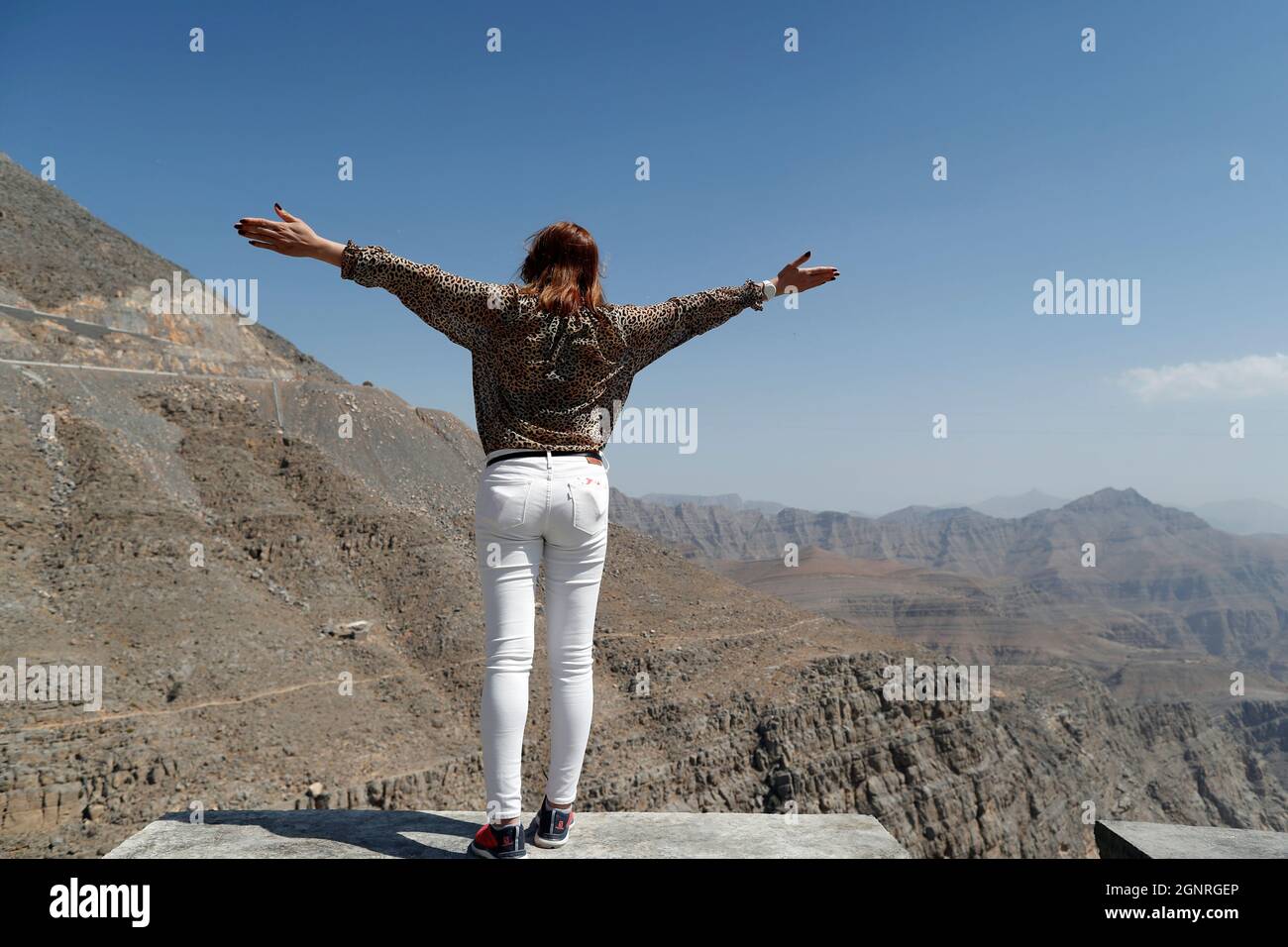 Frau, die die Wüstenlandschaft genießt. Jebel Jais. Vereinigte Arabische Emirate. Stockfoto