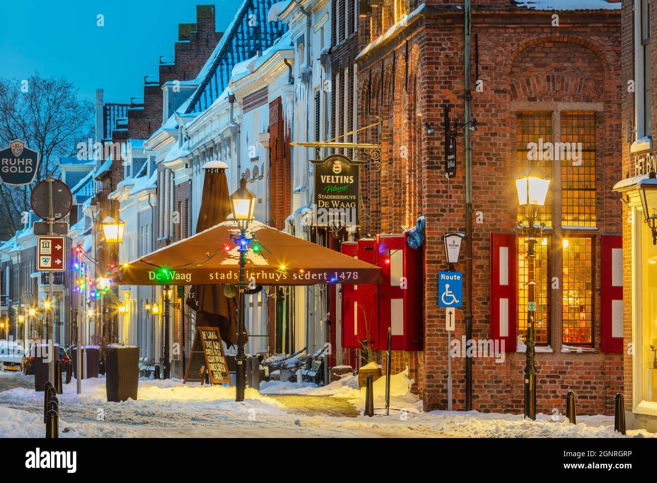 Doesburg, Niederlande - 10. Februar 2021: Schneebedeckte historische Straße mit Restaurants und weihnachtsschmuck im Winter in Doesburg, T Stockfoto