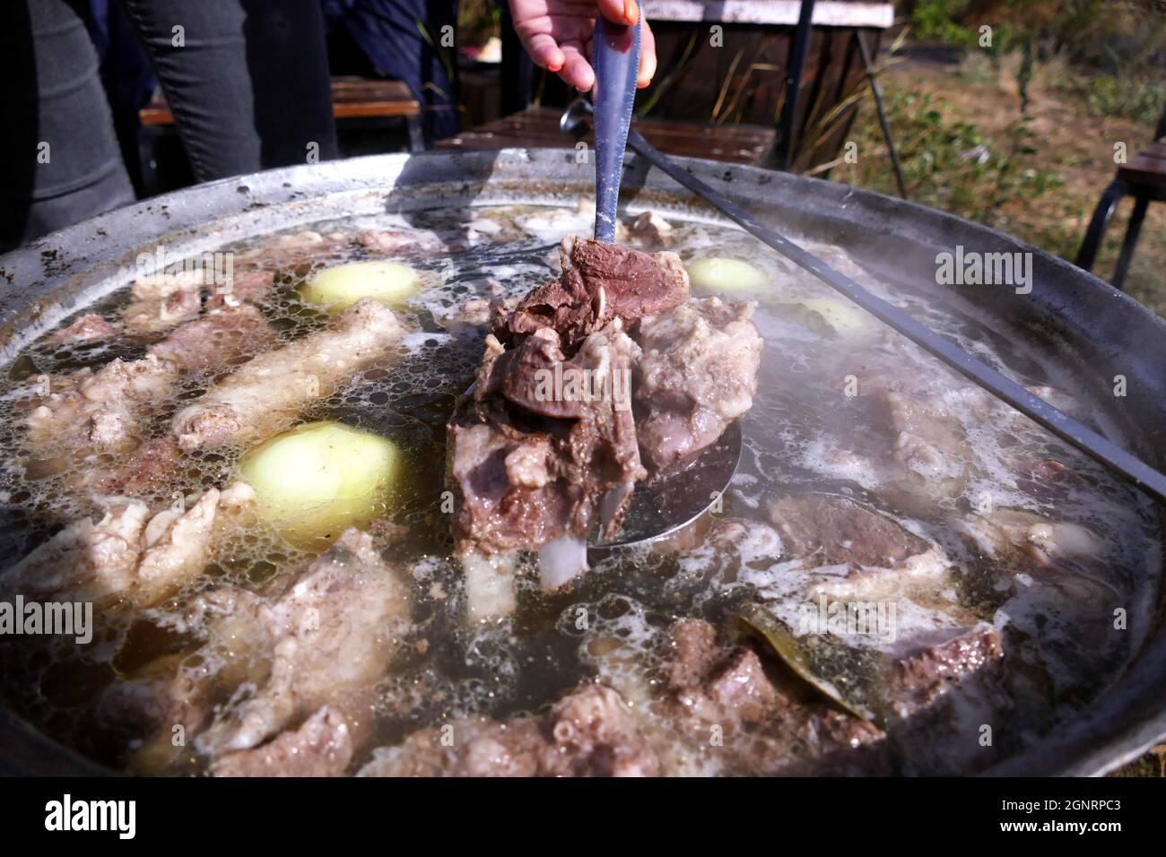 ODESA REGION, UKRAINE - 25. SEPTEMBER 2021 - Ein Koch rührt Brühe im Kessel während des Tarutino Steppe Ethno-und Umweltfestivals gewidmet Stockfoto