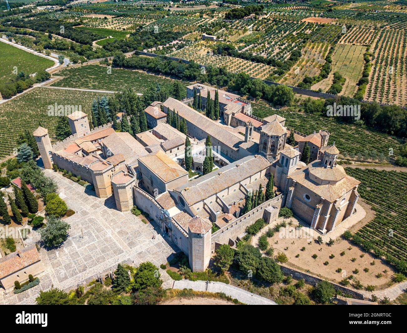 Luftaufnahme des Klosters Santa Maria de Poblet und der umliegenden Felder in Poblet, Vimbodí, Tarragona, Katalonien, Spanien. Dieses Kloster von Poblet wa Stockfoto