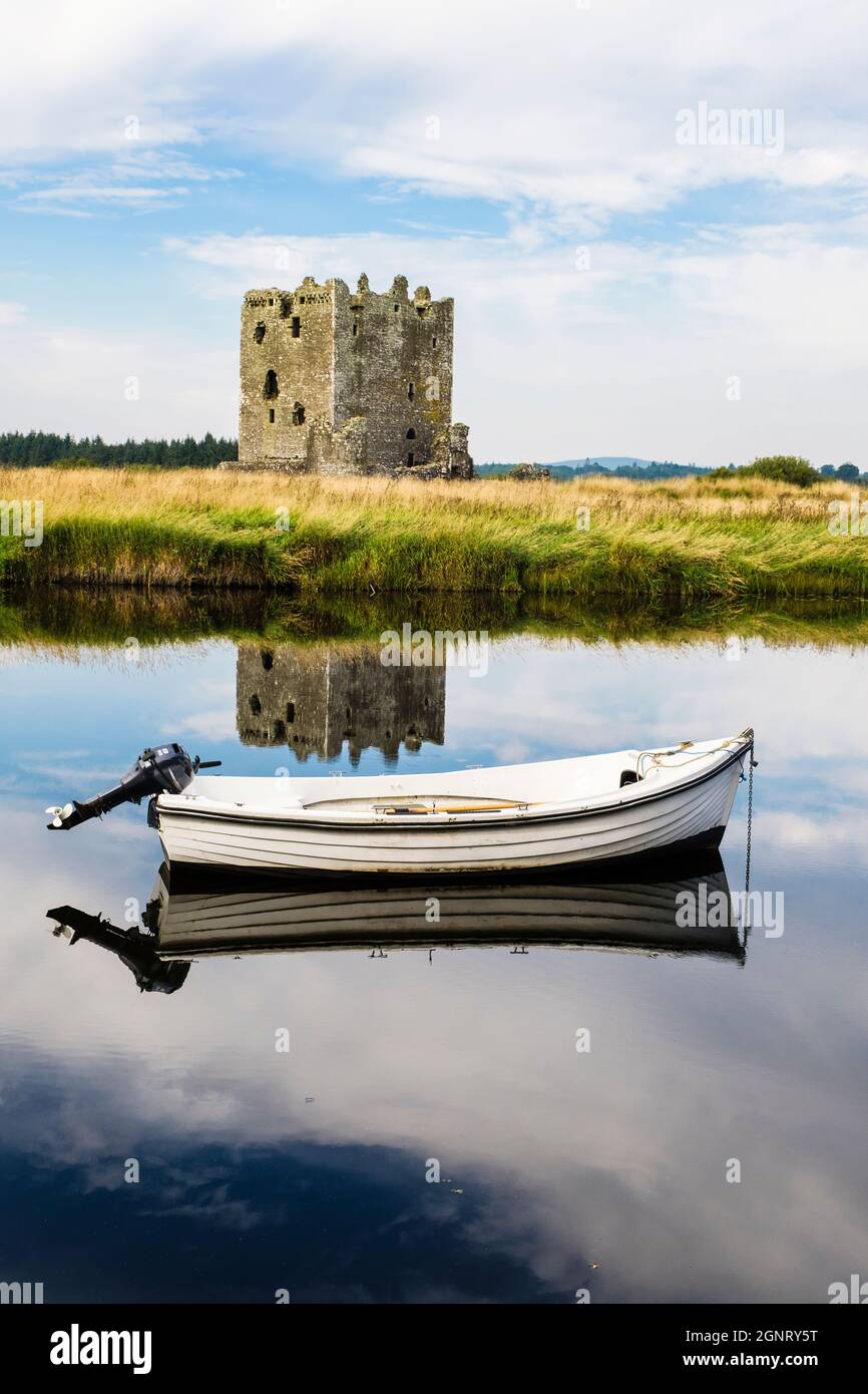 Threave Castle spiegelt sich in den ruhigen Gewässern des Flusses Dee mit einer kleinen Fähre. Threave, Castle Douglas, Dumfries und Galloway, Schottland, Großbritannien, Großbritannien Stockfoto